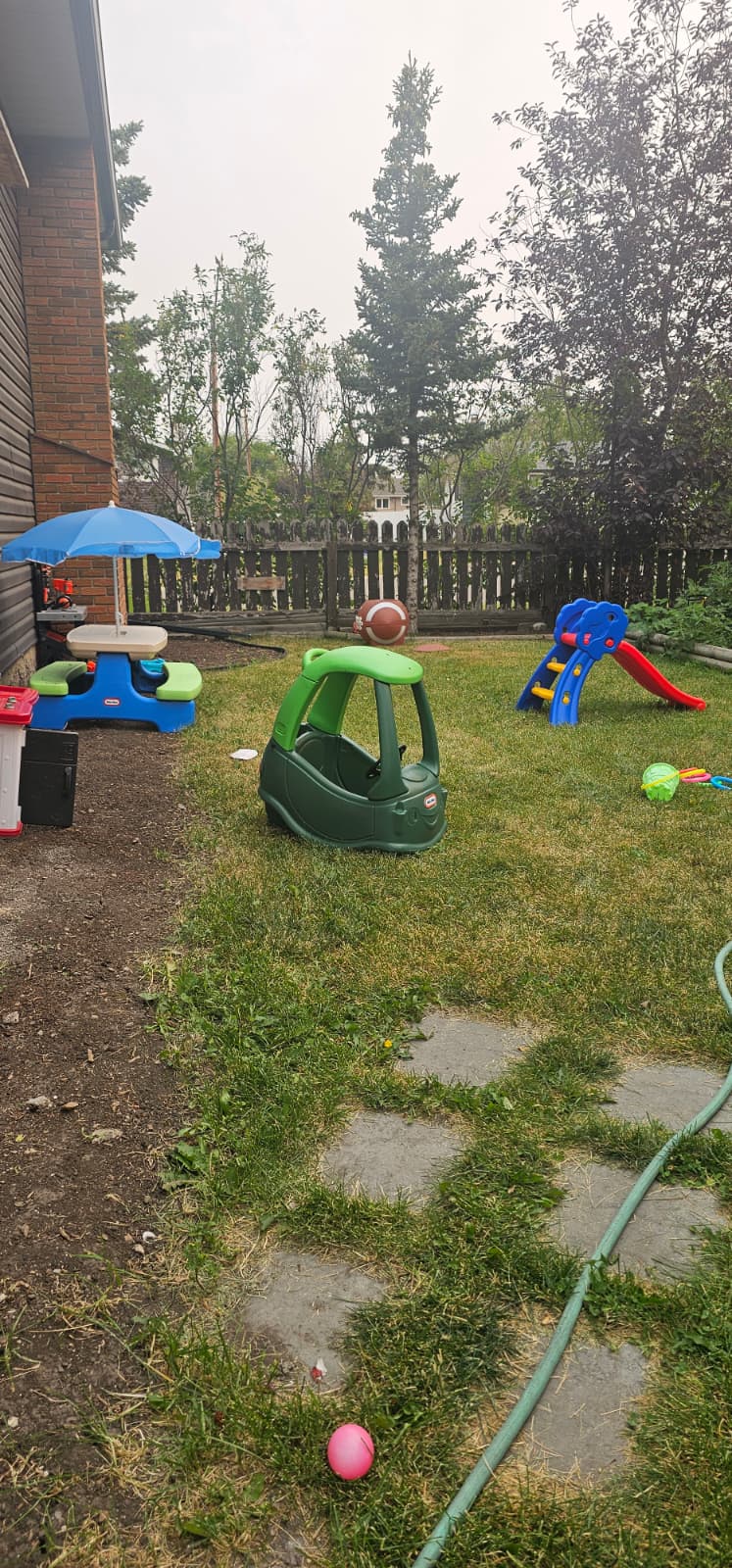 Outdoor daycare play area with toys arranged on the grass